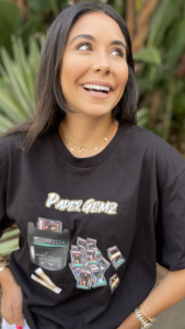 Woman smiling and looking up while wearing a Paper Gemz shirt